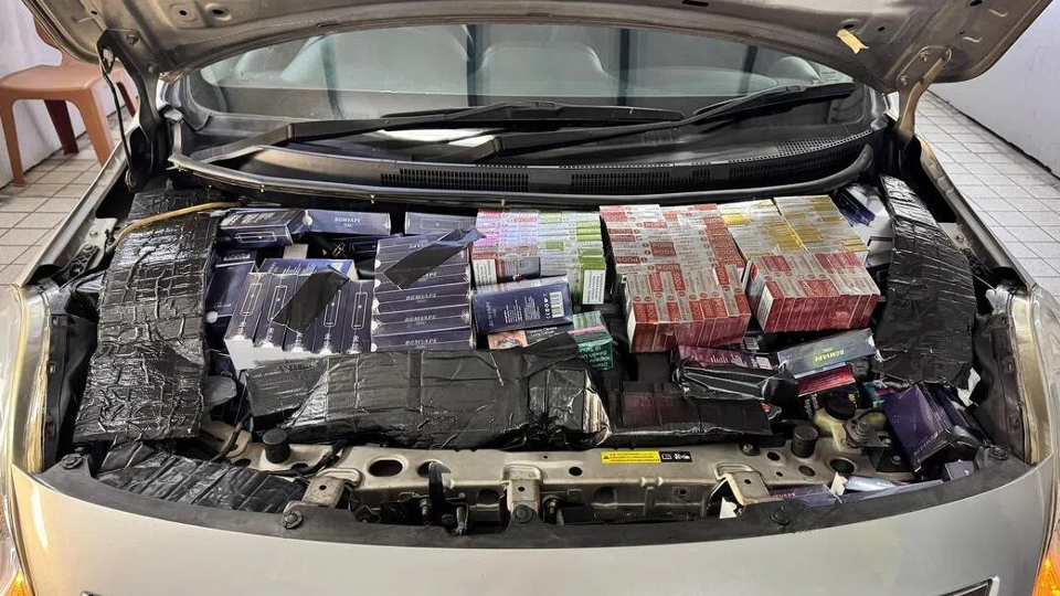 2. caption only (max 150 characters): Illicit fireworks hidden under the hood of a car seized by authorities, highlighting smuggling attempts for dangerous items.