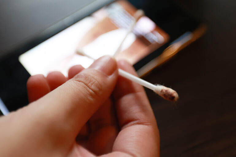 Smoking on smartphone with matchstick, indoor setting, casual attire, close-up, addiction concept.