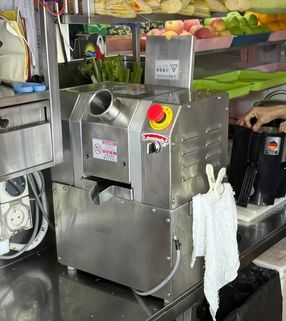 Commercial fruit processing machine in a vibrant produce market.