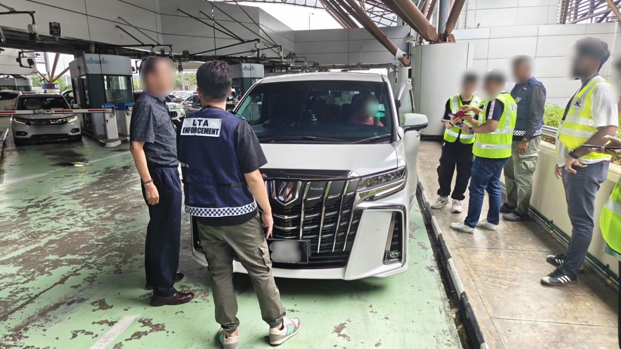 LTA enforcement officers inspecting a white van at a car park.